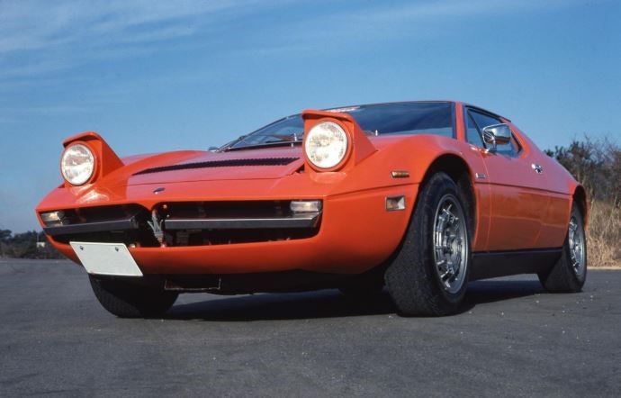 Maserati Merak orange avec phares escamotables ouverts, vue de face