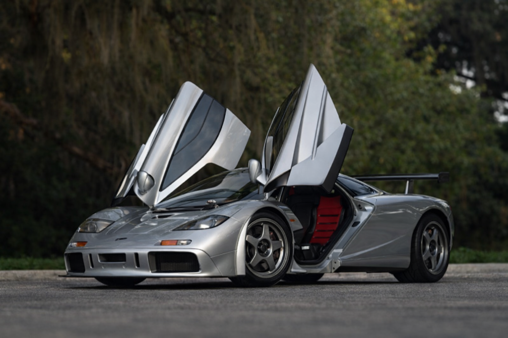 McLaren F1 vue trois quarts avant avec portes papillon ouvertes dans un cadre naturel