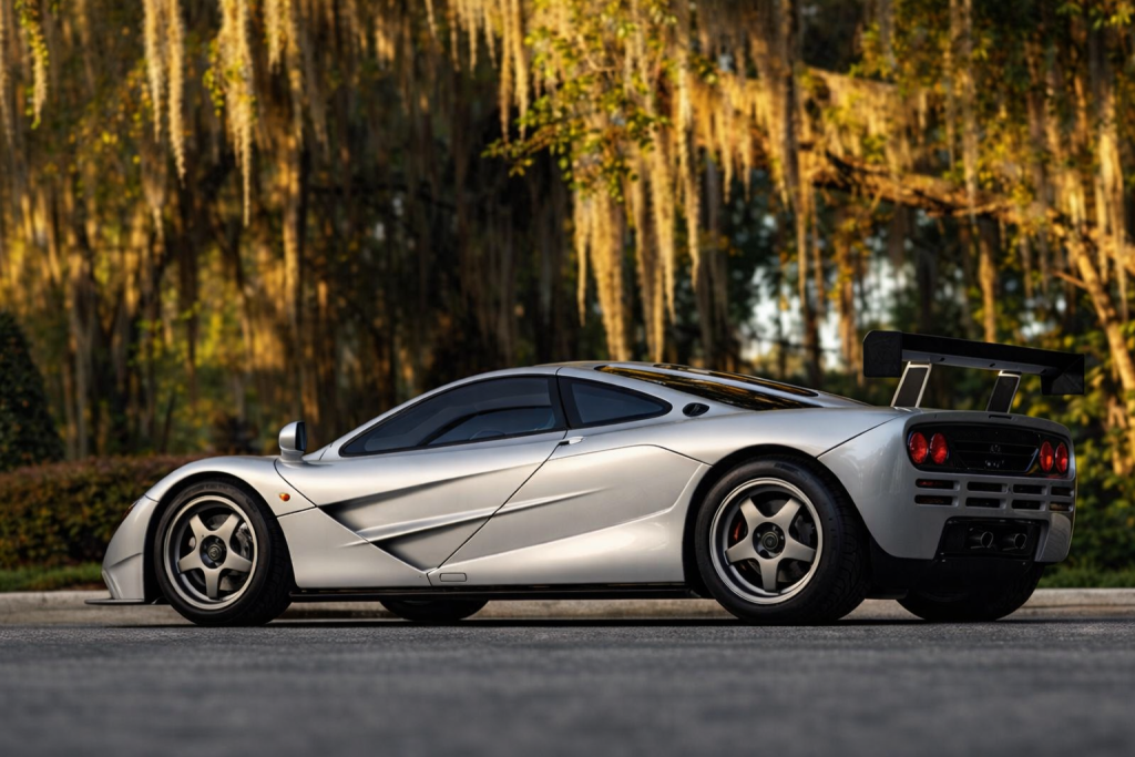 Profil complet de la McLaren F1 argentée, supercar mythique stationnée en extérieur