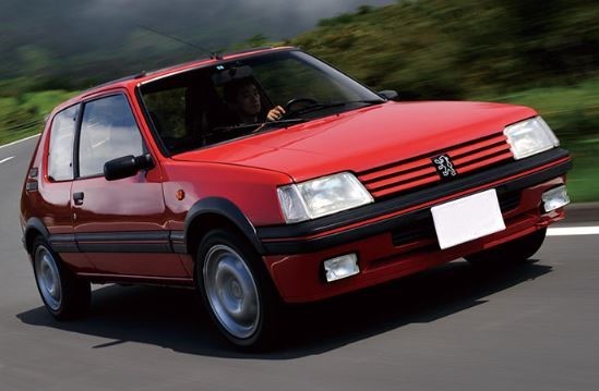 Peugeot 205 GTI rouge en action, vue trois quarts avant