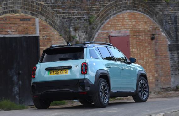 Vue arrière roulante de la Renault 4 E-Tech électrique dans une rue urbaine