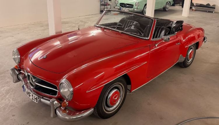 Mercedes 190 SL de 1956 stationnée en parking, roadster classique à carrosserie claire, vue de trois-quarts avant