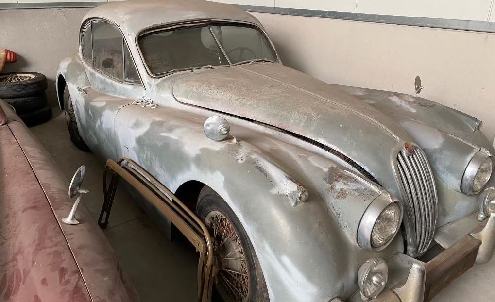 Jaguar XK140 Fixed Head Coupé de 1956 dans un garage, carrosserie classique, vue de trois-quarts avant