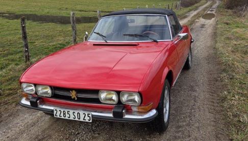 Peugeot 504 Cabriolet 1972 rouge photographiée sur un chemin rural