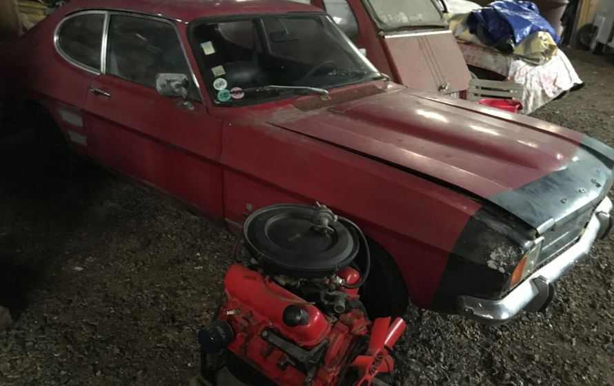 Ford Capri MK1 V6 1971 sortie de grange, carrosserie rouge fatiguée et moteur posé devant la voiture