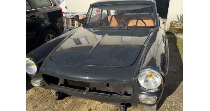 Peugeot 404 Coupé 1965 blanche stationnée en extérieur, carrosserie marquée par le temps