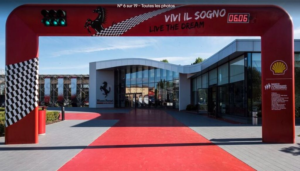 Entrée du musée Ferrari à Maranello avec arche rouge et logo du cheval cabré