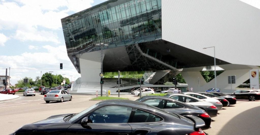 Bâtiment moderne du musée Porsche à Stuttgart avec voitures stationnées devant