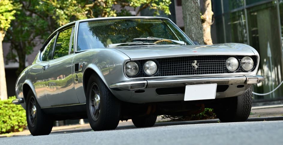 Fiat Dino Coupé argentée, vue de trois-quarts avant en milieu urbain