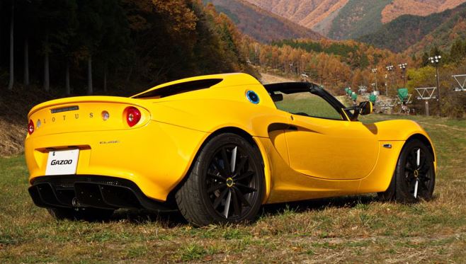 Lotus Elise jaune moderne, vue arrière en extérieur sur terrain herbeux
