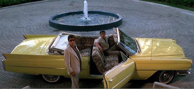 Cadillac décapotable jaune emblématique du film Scarface devant une villa de luxe à Miami
