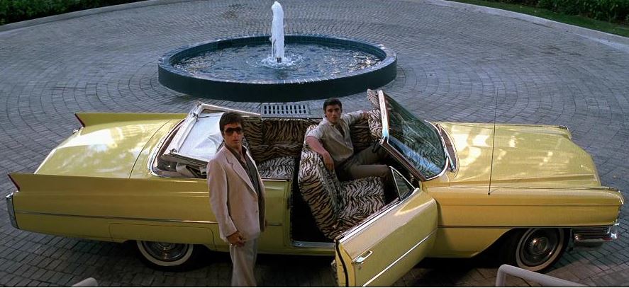 Cadillac décapotable jaune emblématique du film Scarface devant une villa de luxe à Miami
