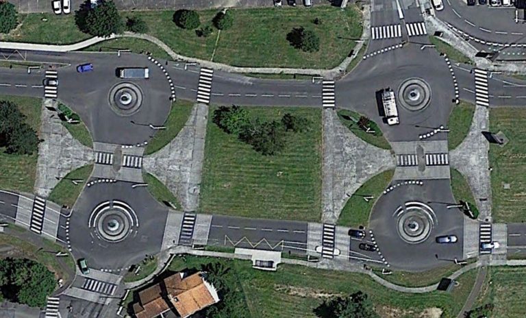 Vue aérienne d’un aménagement routier complexe avec plusieurs ronds-points rapprochés, illustrant des décisions locales pouvant compliquer la circulation.