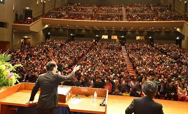 Discours politique devant une grande assemblée dans une salle de conférence
