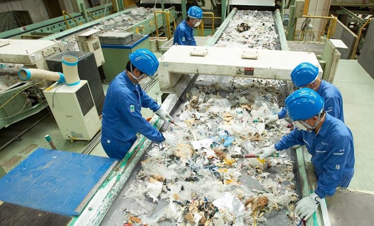Centre de tri des déchets avec des opérateurs triant des matériaux recyclables