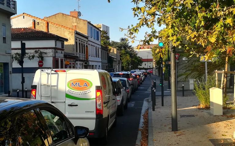 File de voitures ralenties dans une rue urbaine illustrant un trafic dense