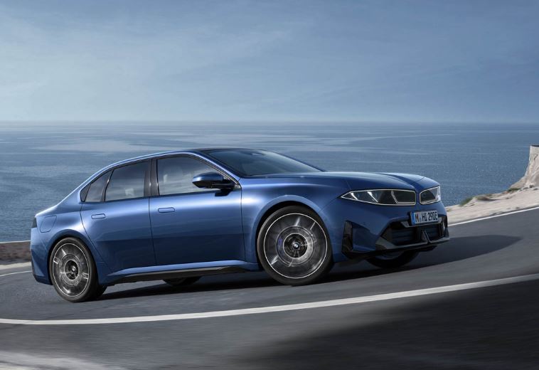 Nouvelle BMW i3 électrique bleue en roulage vue de profil sur route côtière