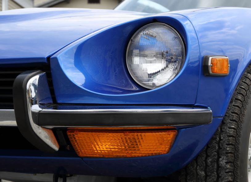 détail du phare rond et du clignotant avant sur une Datsun 240Z bleue