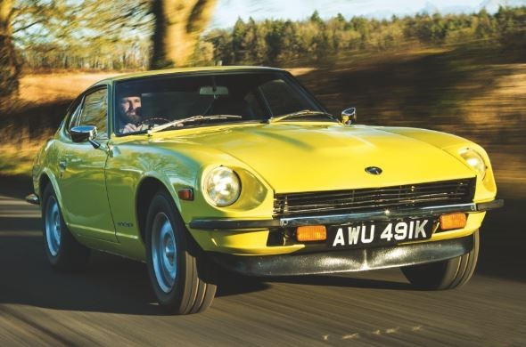 Datsun 240Z jaune roulant sur route de campagne avec son long capot caractéristique