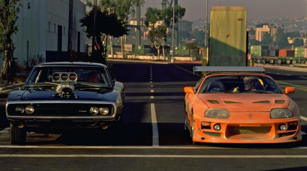 Dodge Charger noire face à Toyota Supra orange au départ d’une course dans Fast and Furious 2001