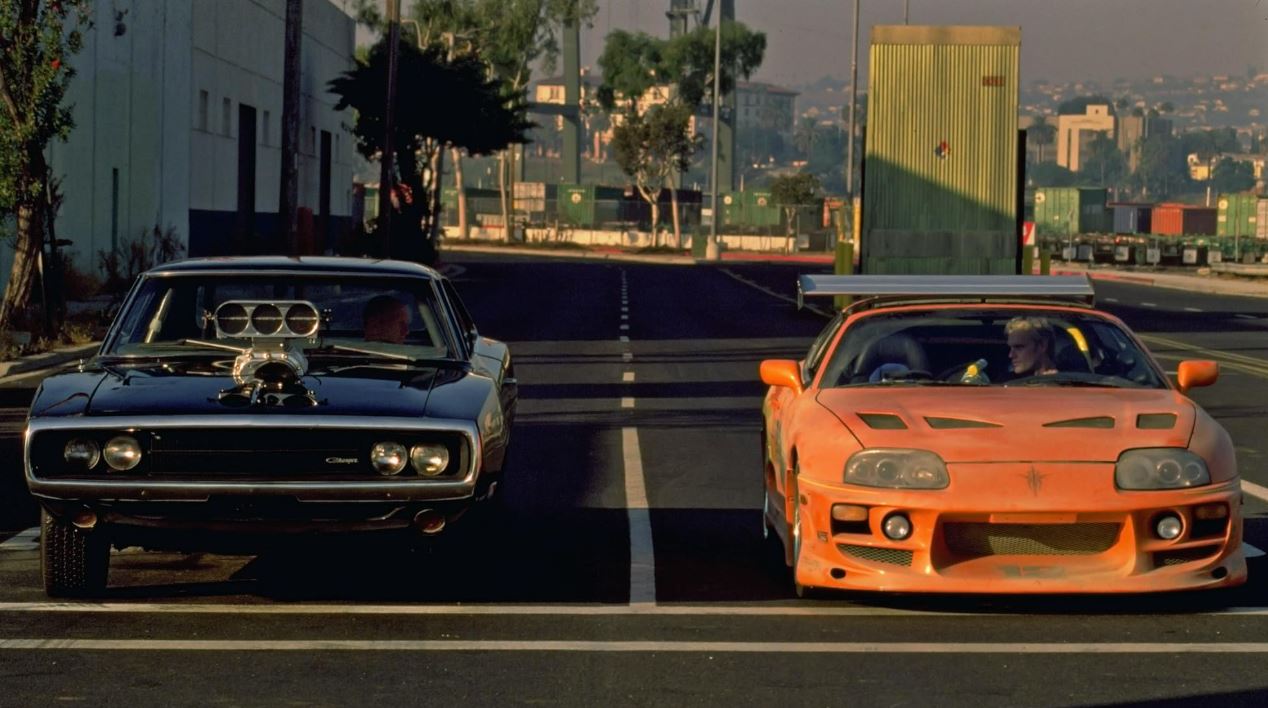 Dodge Charger noire face à Toyota Supra orange au départ d’une course dans Fast and Furious 2001