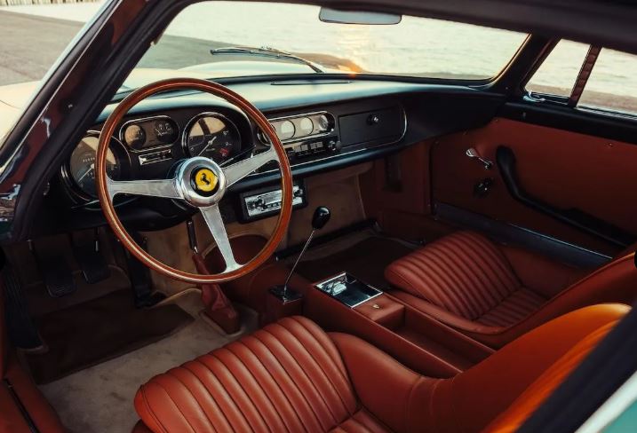 Habitacle marron d’une Ferrari 275 GTB avec volant bois et sièges en cuir