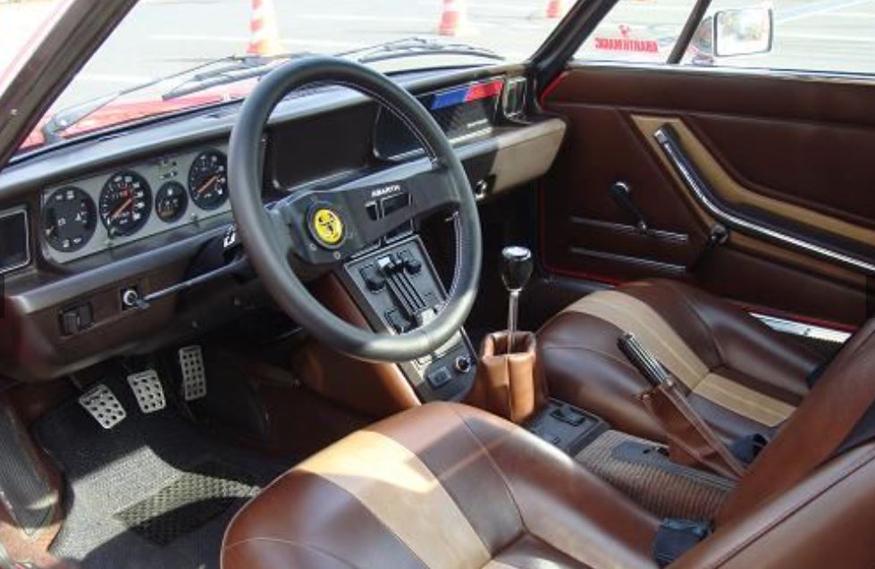 Intérieur de Fiat X1/9 avec tableau de bord simple et sièges en cuir marron