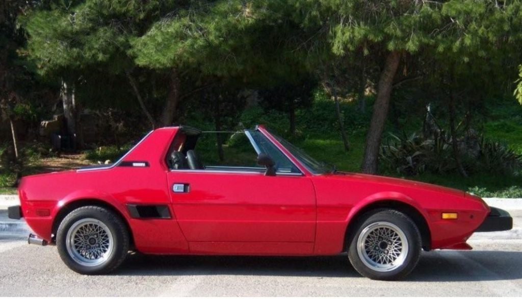 Fiat X1/9 rouge en profil avec toit targa retiré, proportions compactes et sportives