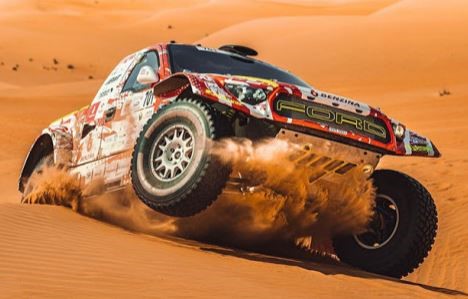 véhicule tout terrain progressant dans les dunes lors d’un rallye raid au Moyen-Orient