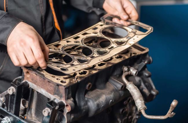 Joint de culasse posé sur bloc moteur montrant les correspondances des alésages et passages de liquide