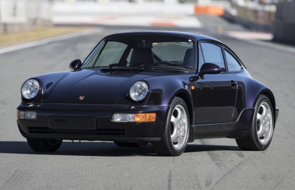 Porsche 911 964 Carrera 4 stationnée sur circuit, silhouette classique modernisée