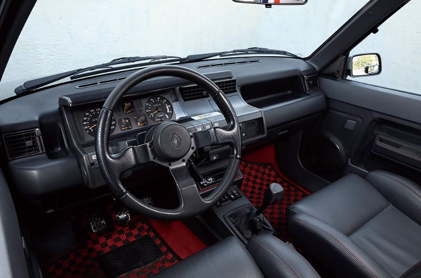 Intérieur Renault 5 GT Turbo avec tableau de bord d’origine et moquette rouge à damier