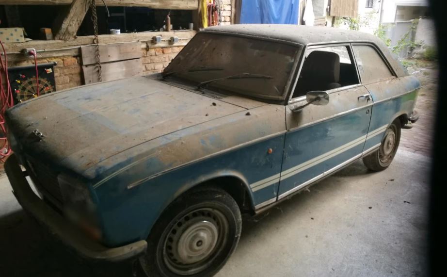 Peugeot 304 Coupé 1975 bleu poussiéreuse stationnée dans un garage ancien