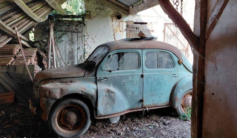 Renault 4CV 1960 abandonnée dans une grange, carrosserie bleu pâle patinée et roues rouillées