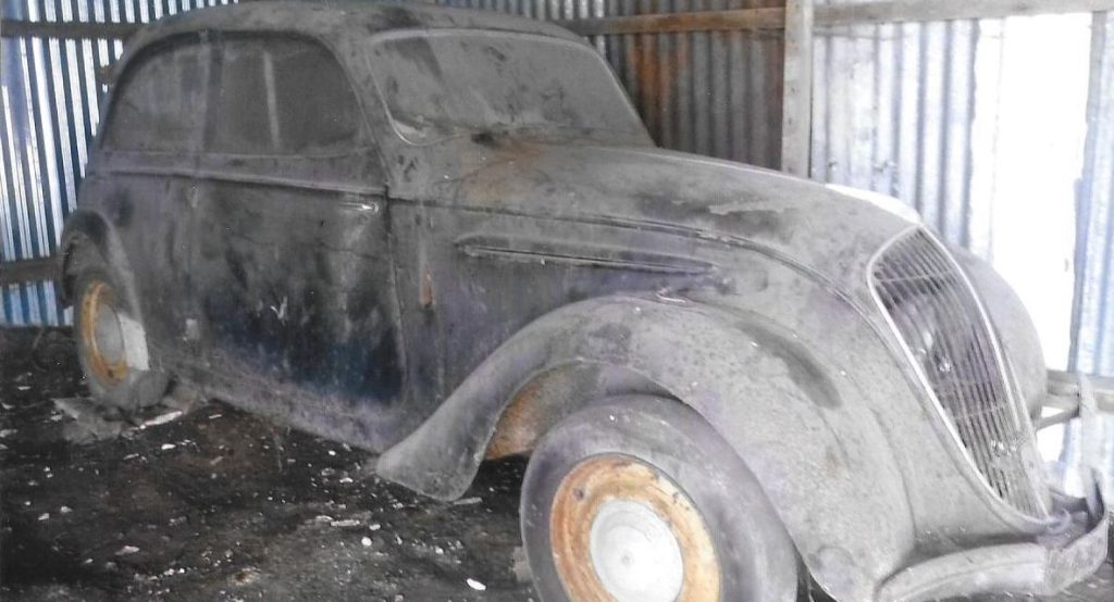 Peugeot 202 BH 1948 couverte de poussière dans une grange