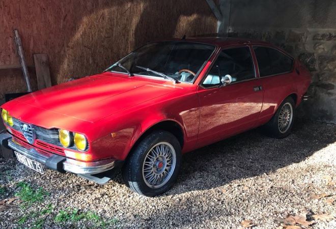 Alfa Romeo GTV 2 litres 1981 rouge stationnée sous abri après une longue immobilisation