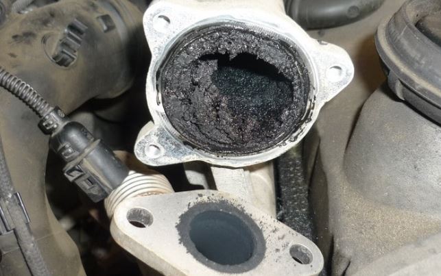 vanne EGR encrassée avec dépôts de suie importants dans conduit moteur