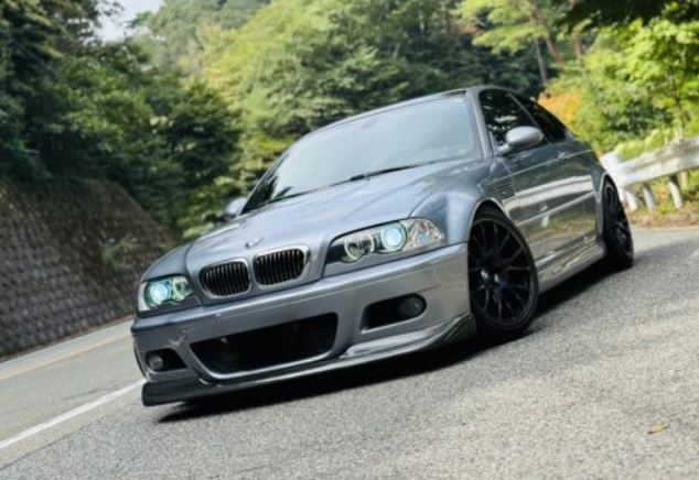 BMW M3 E46 grise roulant sur route de montagne