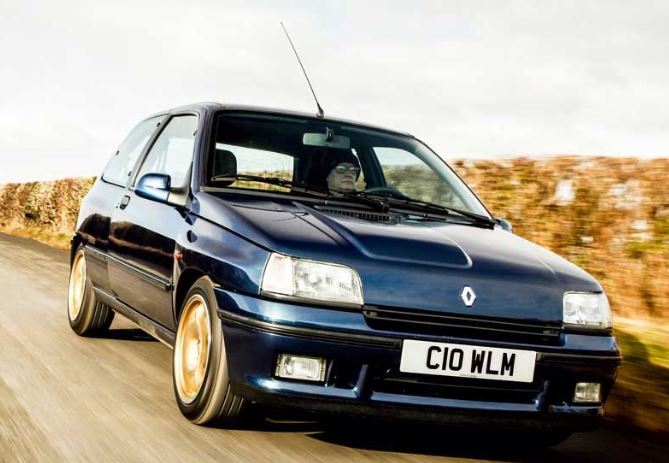 Renault Clio Williams bleue avec jantes dorées roulant sur route