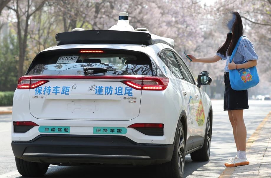 Passagère appelant un taxi autonome chinois équipé de capteurs sur le toit