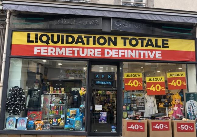 Vitrine de magasin en centre-ville avec liquidation totale et fermeture définitive