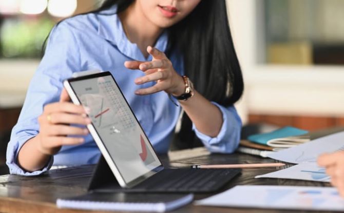 Personne expliquant un graphique sur une tablette lors d’une discussion