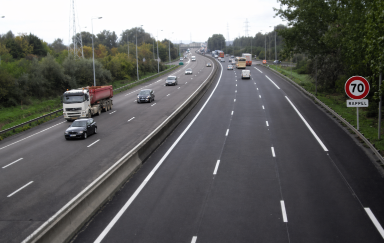 Autoroute multi-voies avec trafic fluide et panneau de limitation 70 km/h rappel sur le côté