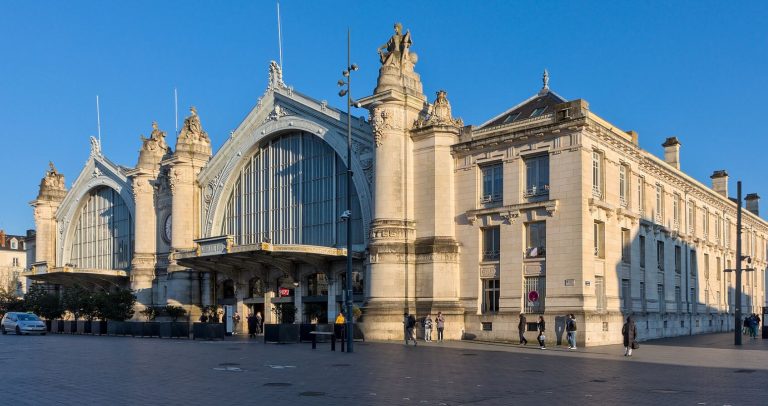 Façade monumentale de la gare de Tours sous un ciel bleu