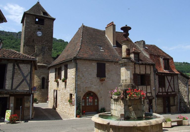 Place d’un village en zone rurale avec fontaine et clocher ancien