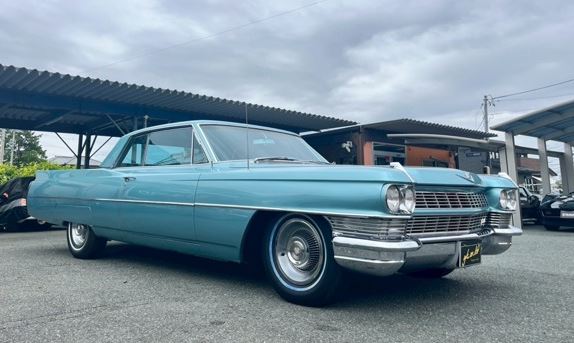 Cadillac DeVille berline américaine années 60 stationnée en extérieur, symbole des grandes voitures US en Europe