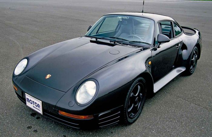 Porsche 959 noire trois quarts avant posée sur circuit