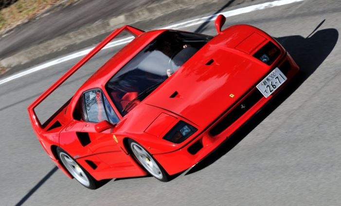 Ferrari F40 rouge en mouvement sur route vue plongeante trois quarts avant