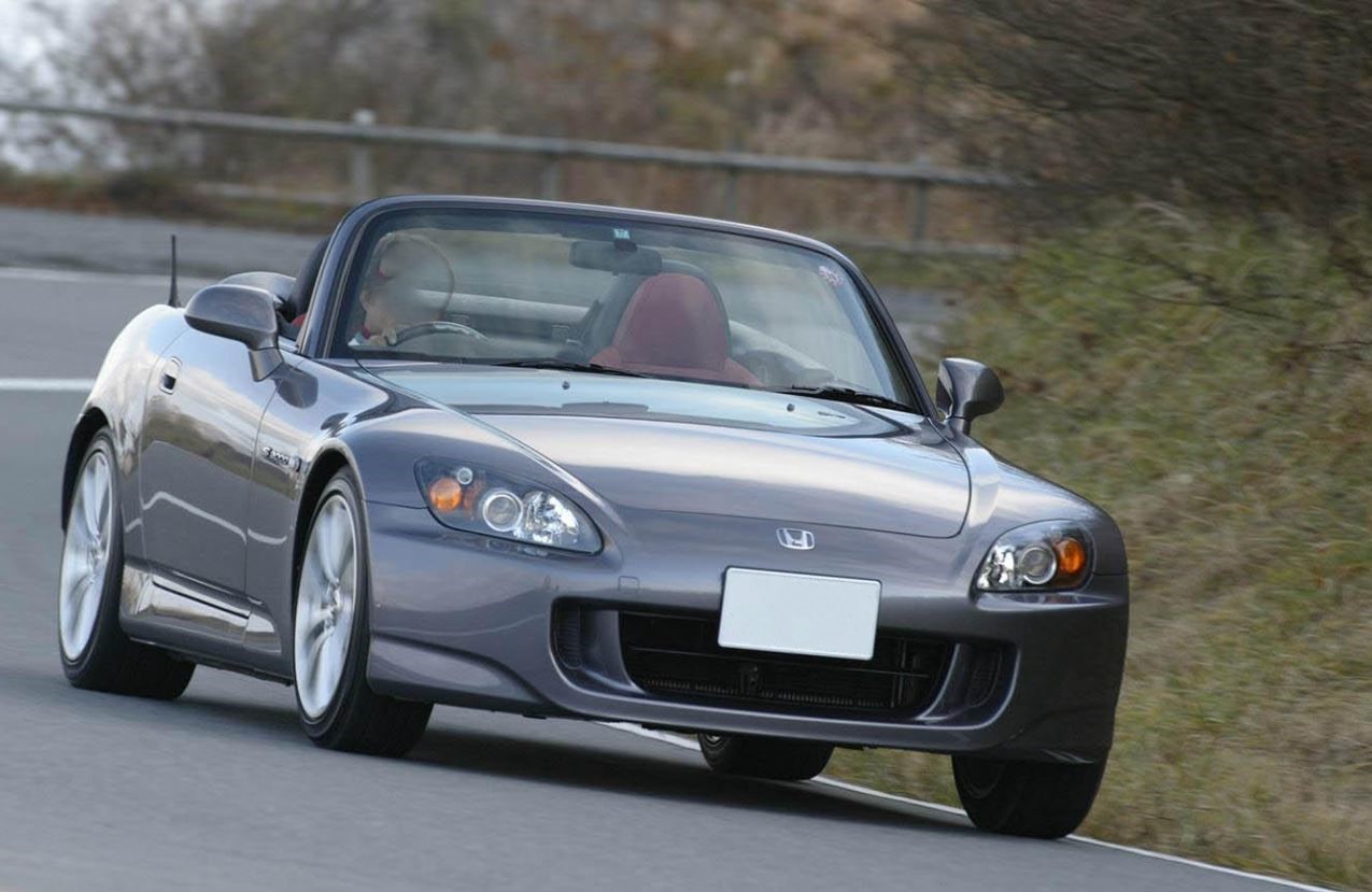 Honda S2000 grise en mouvement sur route, roadster sportif japonais propulsion