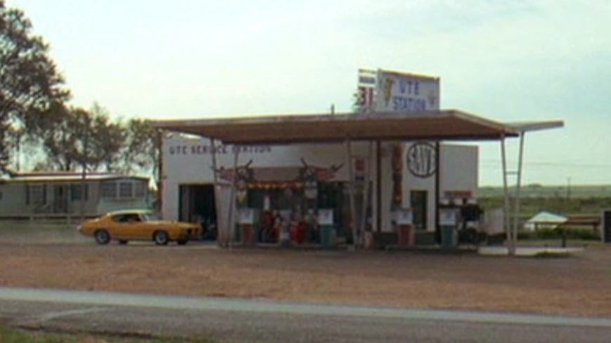 station-service américaine avec Pontiac GTO dans Macadam à deux voies